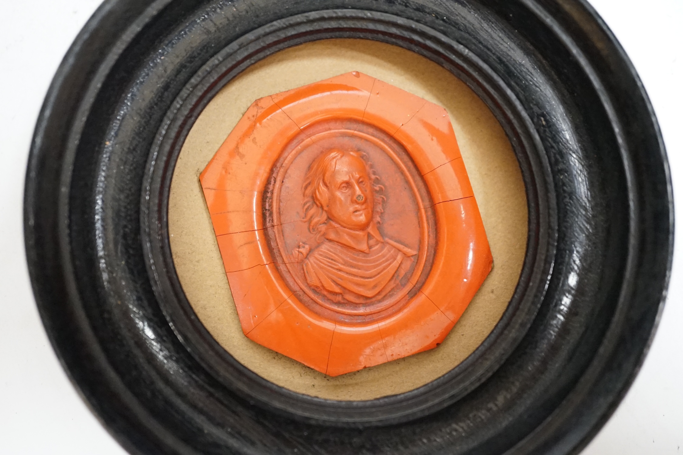A framed red wax portrait of Oliver Cromwell, label verso reads ‘Oliver Cromwell the founder of English Liberty born 1599 died 1658 Emilie J. Bosignieu? 19-/68?’, 8.5cm diameter. Condition - fair
